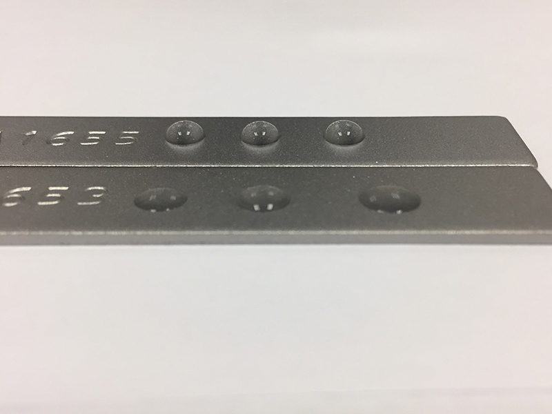 Figure 2: Carbon Steel treated with 10ppm active FFA for 1hr (top) vs no treatment (bottom). Treated coupon shows a significant difference in contact angle of water droplets, signifying a hydrophobic surface.